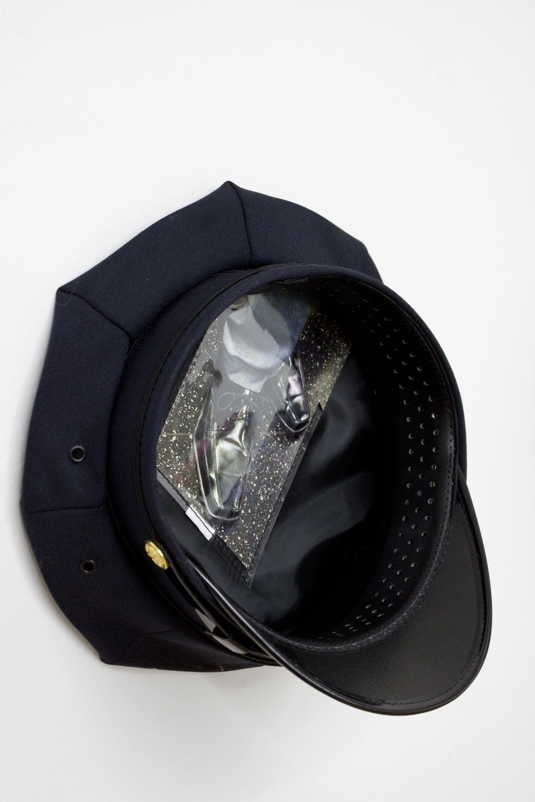 Under Their Hats (box toe 1), 2017 Police issued hat, digital c-print 10 x 10 x 5 1/2 inches / 25.4 x 25.4 x 14 cm