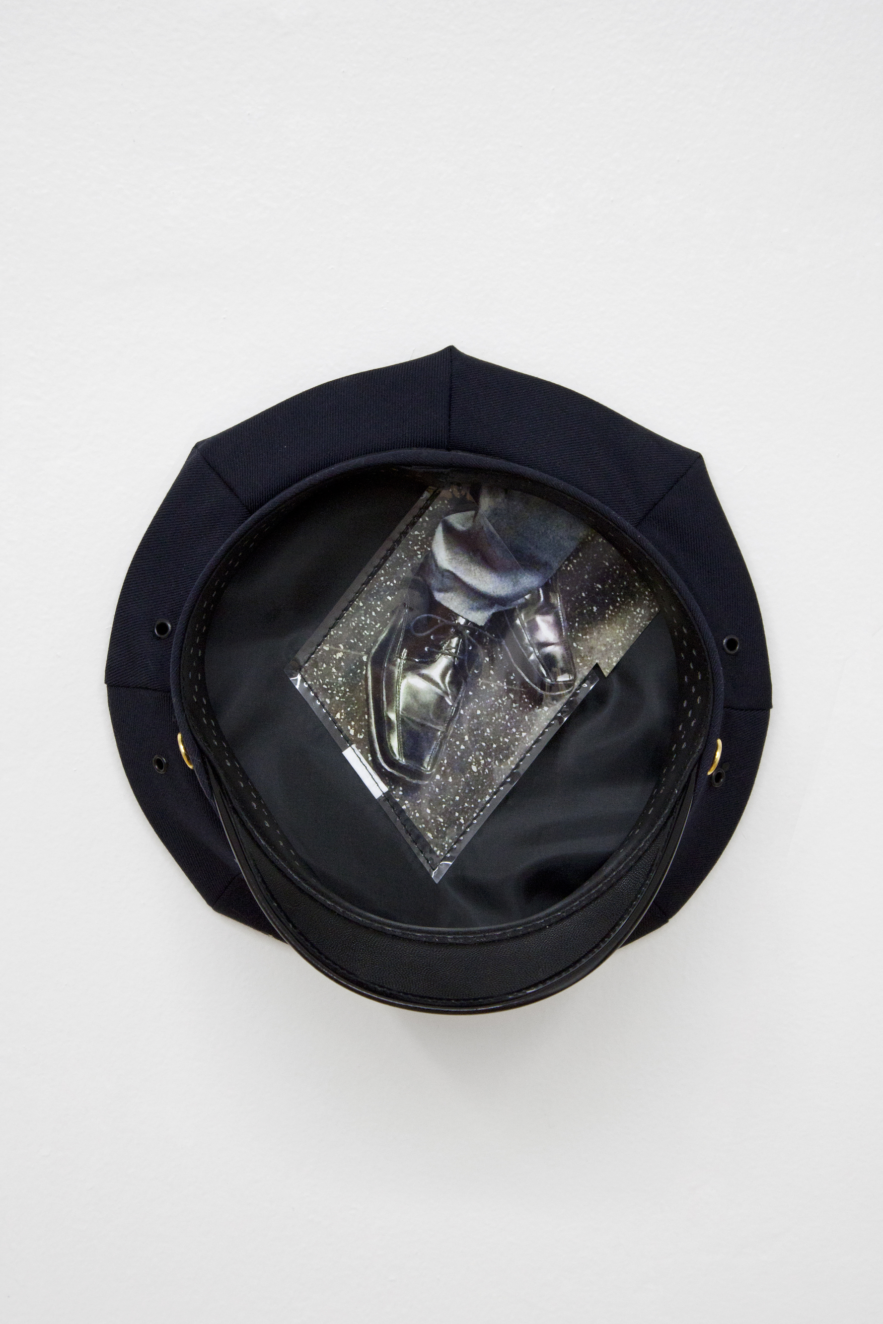 Under Their Hats (box toe 1), 2017 (detail) Police issued hat, digital c-print 10 x 10 x 5 1/2 inches / 25.4 x 25.4 x 14 cm